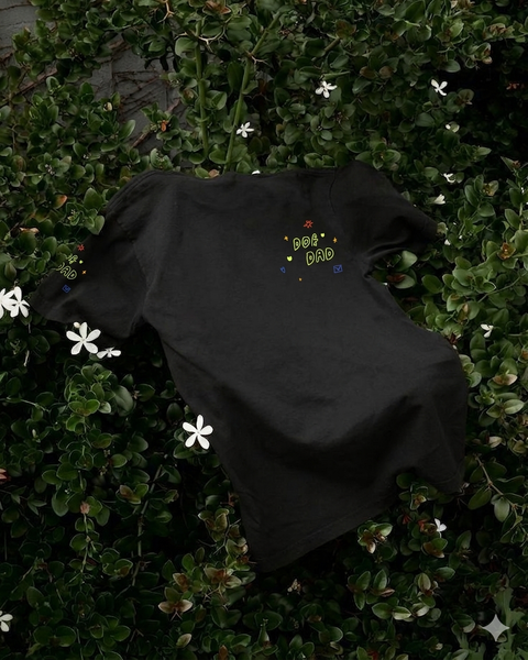 Black t-shirt with 'dog Dad' embroidery on a green leafy background